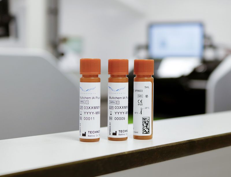 Multichem IA Plus immunoassay quality controls sit on a laboratory bench with Abbott Alinity analyzer in the background